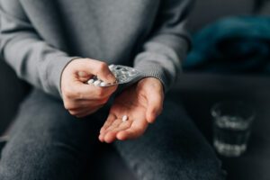 Female hands holding pills.
