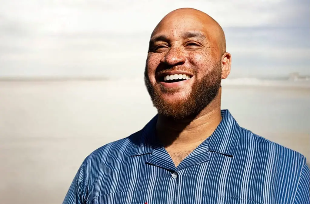 Smiling man with beard wearing a blue striped shirt